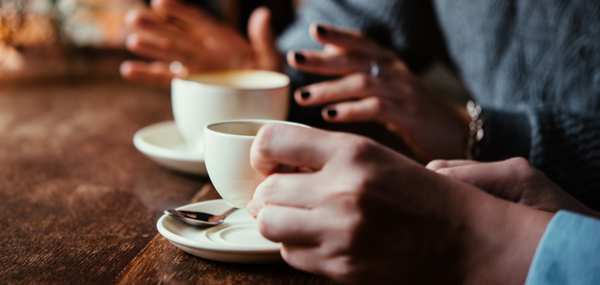 Two people talking while having coffee Cafs Foster Care team