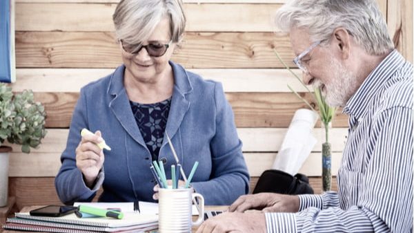 Cafs How Shirley and Alec found the right time to become Cafs Foster Carers Cafs Foster Carers woman and man sitting on the table writing down their Foster Care FAQs.