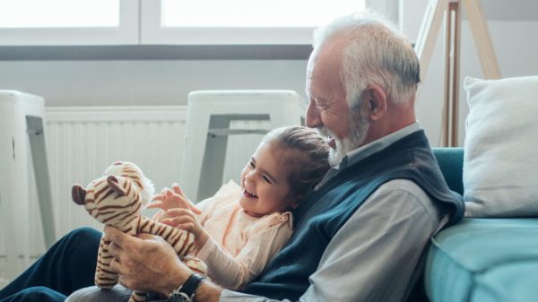 Cafs – Kinship Care Slider Kinship carer and young child playing with the stuffed toy while sitting on the floor
