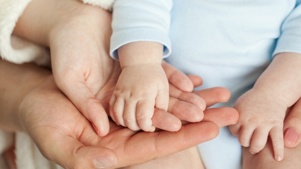 CAFS – Who Can Become a Foster Carer Permanent carers holding their baby's hand