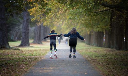 Foster care mother and foster daughter skating in the park
