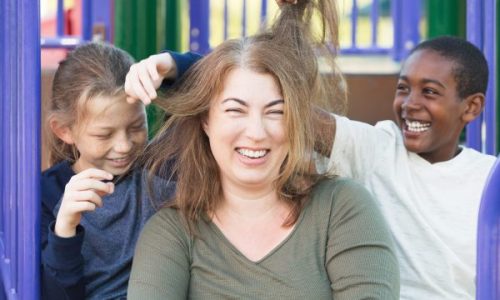 Foster care mother with two foster children playing at the playground